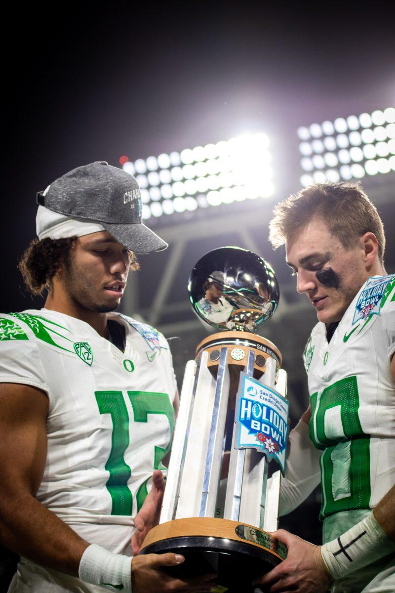 Oregon quarterbacks, Bo Nix (10) and Ty Thompson (13), admire their new piece of hardware on stage during the post game celebrations.&#160;The Oregon Ducks face the North Carolina Tar Heels in the annual Holiday Bowl at Petco Park in San Diego, CA, on December 28th, 2022. (Jonathan Suni, Emerald)