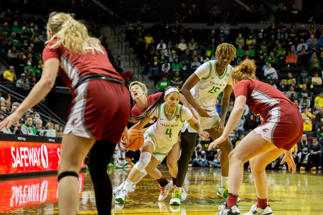 Ducks Endyia Rogers (4) dodges a block and dribbles the ball towards offense. Oregon Ducks take on the Washington Cougars in Eugene, Ore. (Ali Watson/Emerald)