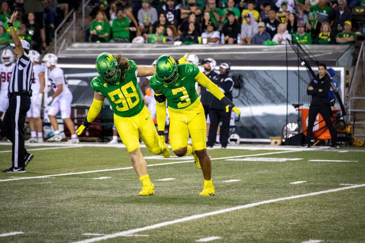 Casey Rogers (98) and Brandon Dorlus (3) celebrate after a big defensive stop. The Ducks host the Cardinals at Autzen Stadium on October 1, 2022 (Jonathan Suni, Emerald.)