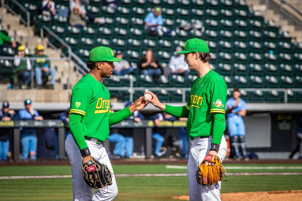 Jacob Walsh (25) hands a ball to Oregon pitcher, Jackson Pace.&#160;The Oregon Baseball team takes on Xavier for their season opening series on Feb. 19th, 2023, at PK Park. (Jonathan Suni, Emerald)