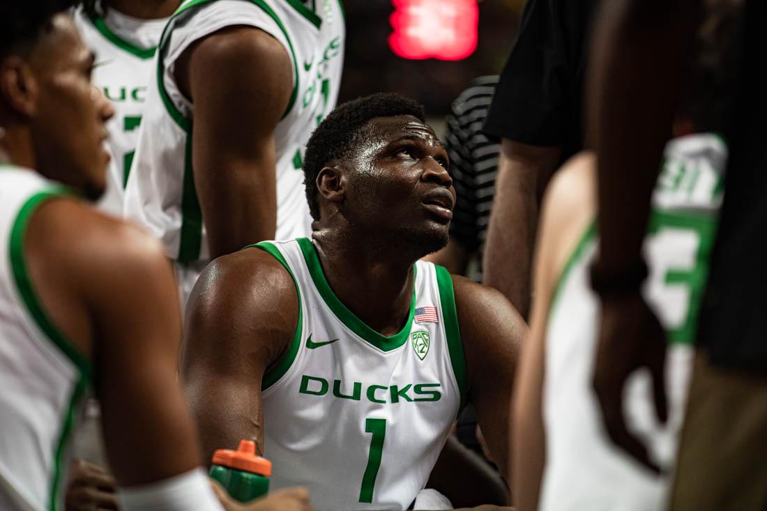 Ducks center N'Faly Dante (1) sits in a team huddle during a timeout called by the Ducks. University of Oregon Mens Basketball defeat the USC Trojans 78-60 at Matthew Knight Arena in Eugene, Ore., on Feb. 9, 2023. (Maddie Stellingwerf/Emerald)