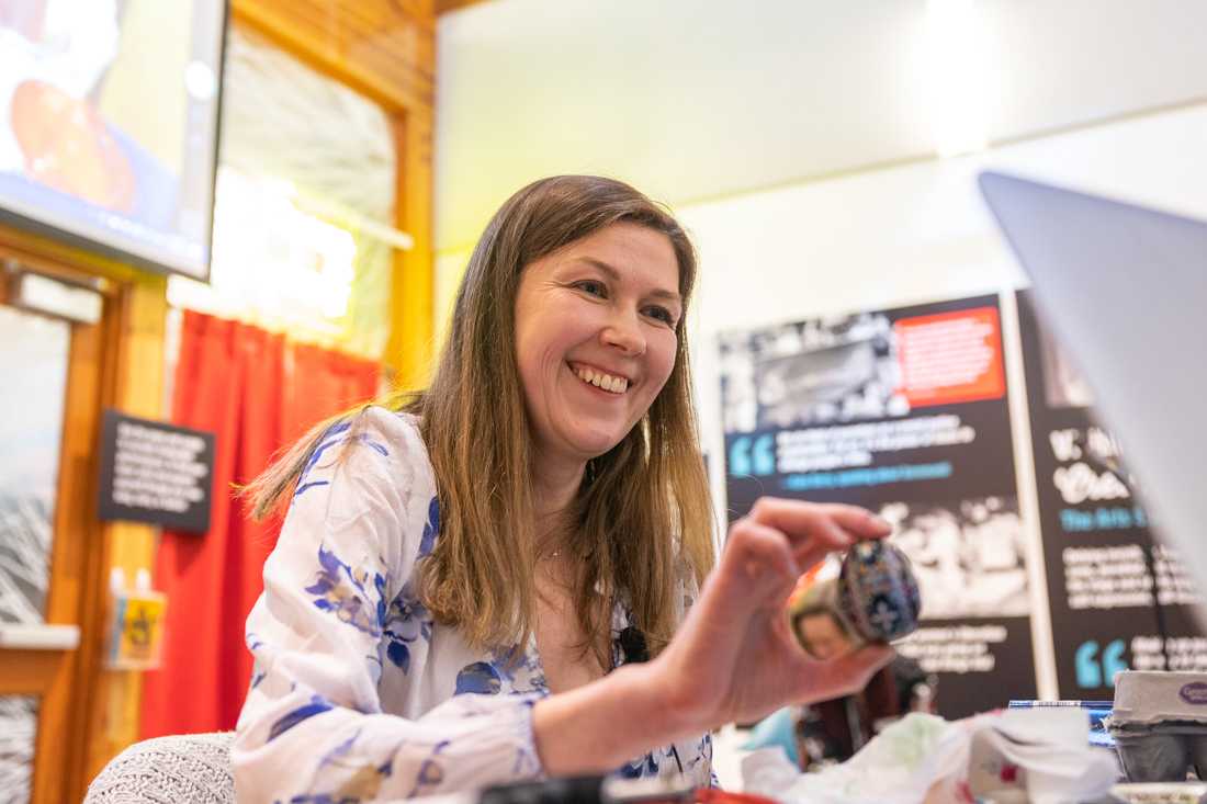 Kristine Mushkevych smiles as she shows the audience the final egg made during the event. Pysanka is a traditional Ukrainian art form that has a lot of cultural and historical significance. Featured artist, Kristine Mushkevych, led a Pysanka event in the Museum of Cultural and Natural History Museum Galleria on Mar. 5, 2023. (Molly McPherson/Emerald)