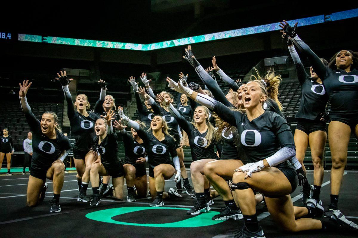 The team joins at the center of the mat and yells "Go Ducks!" to the judges and home crowd to cap off the meet. The Oregon Acrobatics and Tumbling team takes on Baylor on March 8th, 2023, at Matthew Knight Arena. (Jonathan Suni, Emerald)