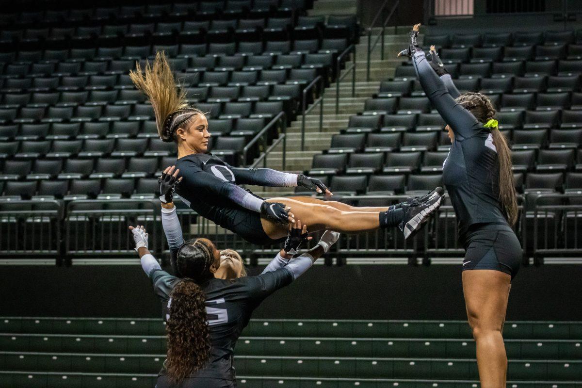 Makena Carrion (36) calmly falls back onto some of her teammates. The Oregon Acrobatics and Tumbling team takes on Baylor on March 8th, 2023, at Matthew Knight Arena. (Jonathan Suni, Emerald)