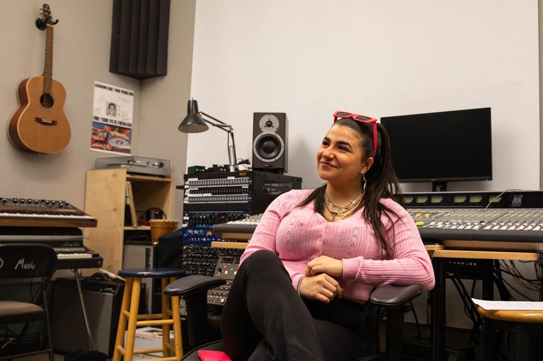 <p>Taylor Jules sits in the Analog recording room inside the University of Oregon's Music School. The room itself holds only analog recording equipment, and was the home of one of her favoruite classes last term. Eugene is home to many independent musicians both in and outside of the University. (Maddie Stellingwerf/Emerald).</p>