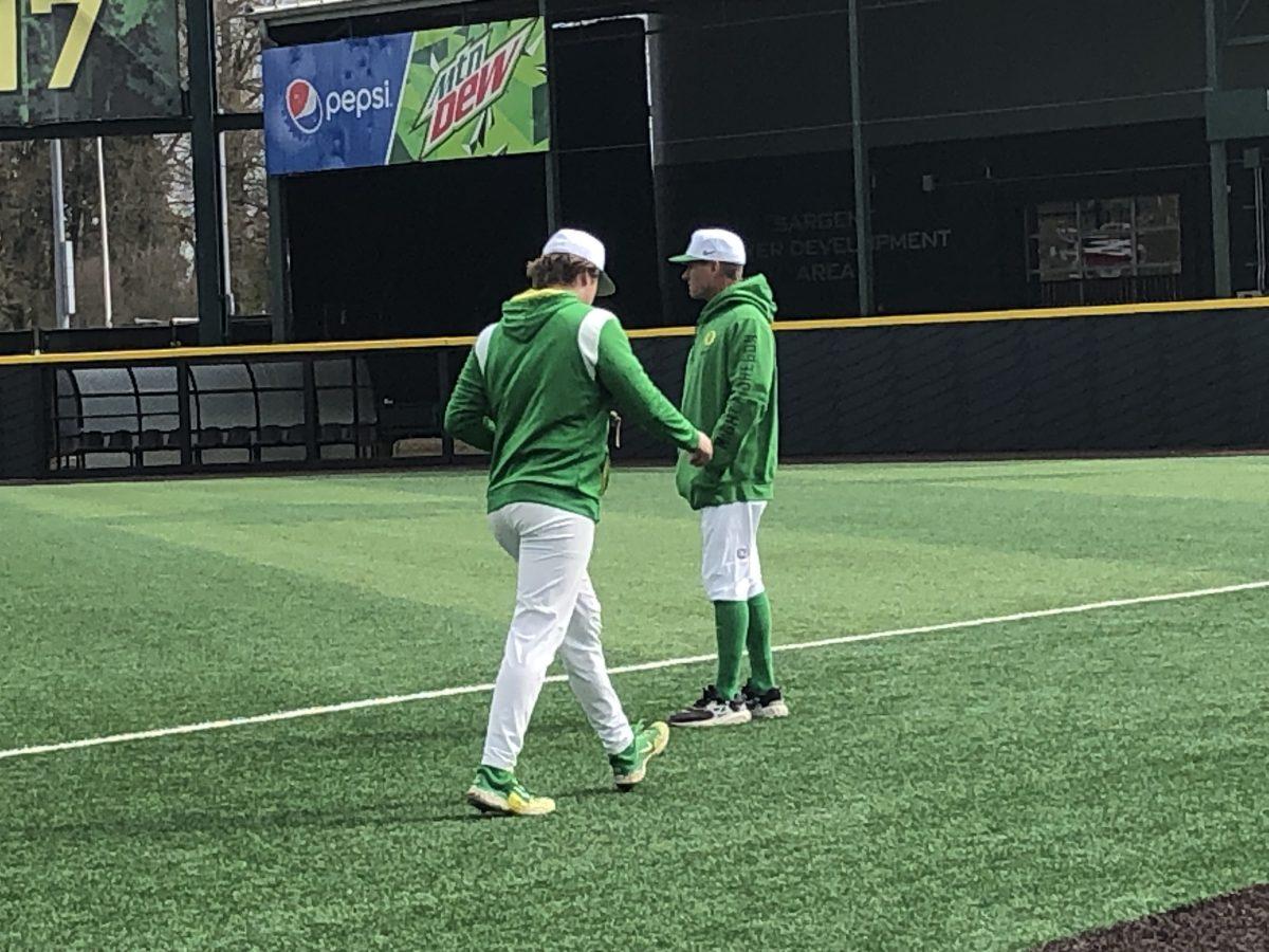 Oregon freshman pitcher Matthew Grabmann walks by head coach Mark Wasikowski before Oregon's game on March 24, 2023. (Mojo Hill/Daily Emerald)