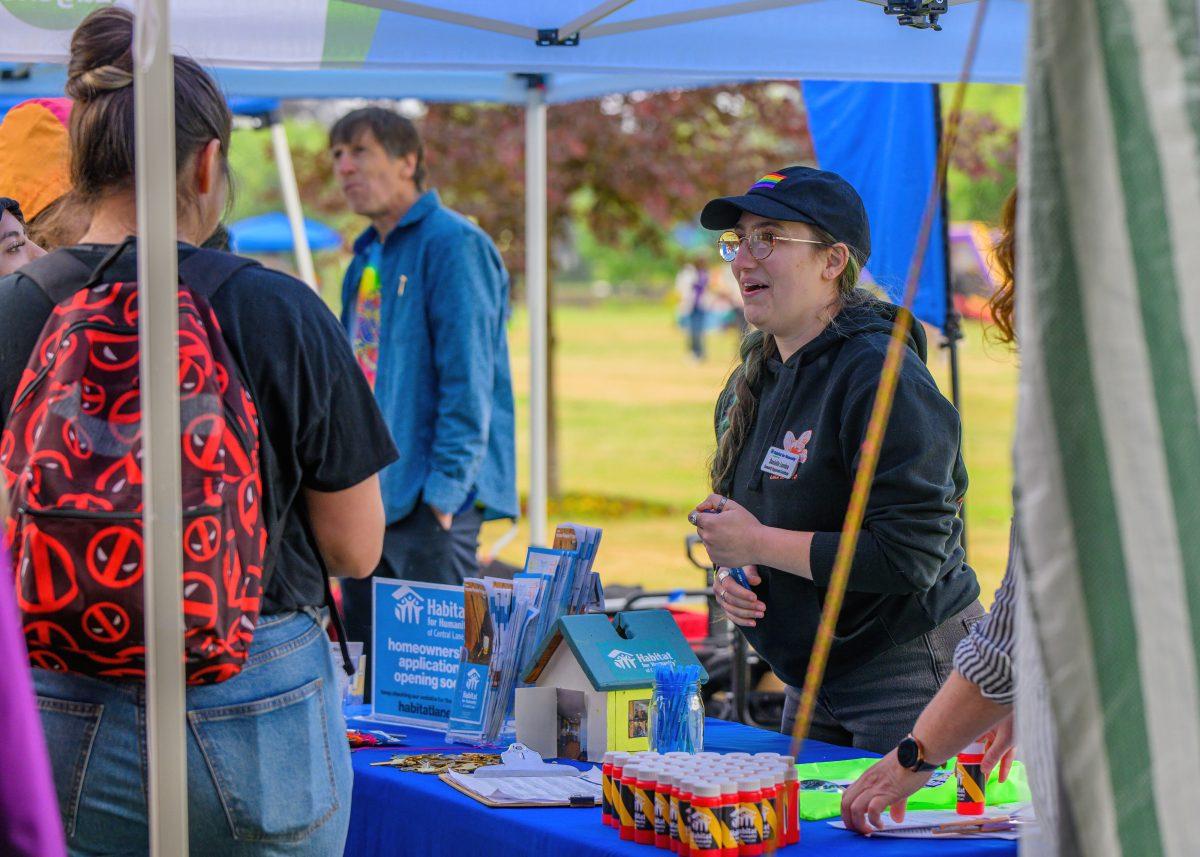 A Habitat for Humanity booth worker interacts with attendees. The holiday Juneteenth, which commemorates the emancipation of enslaved African Americans, was celebrated at Alton Baker Park in Eugene, Oregon, on June 18, 2023. (Eric Becker/Emerald)