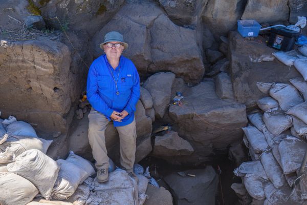 Pat O'Grady poses for a photo in one of the excavation sites. The University of Oregon Archaeological Field School excavates at the Rimrock Draw Rockshelter near Burns, Oregon, on August 1, 2023. (Eric Becker/Emerald)