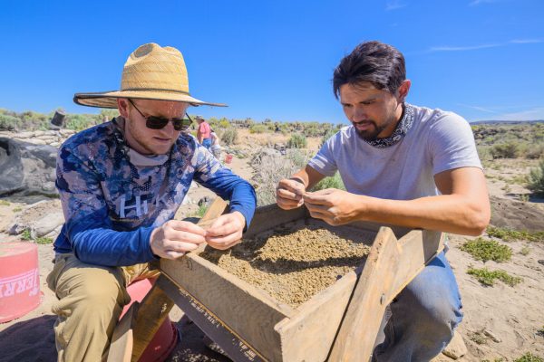 INSERT NAME (right) and Finley Brake (left) sift through excavated material looking for artifacts. The University of Oregon Archaeological Field School excavates at the Rimrock Draw Rockshelter near Burns, Oregon, on August 1, 2023. (Eric Becker/Emerald)