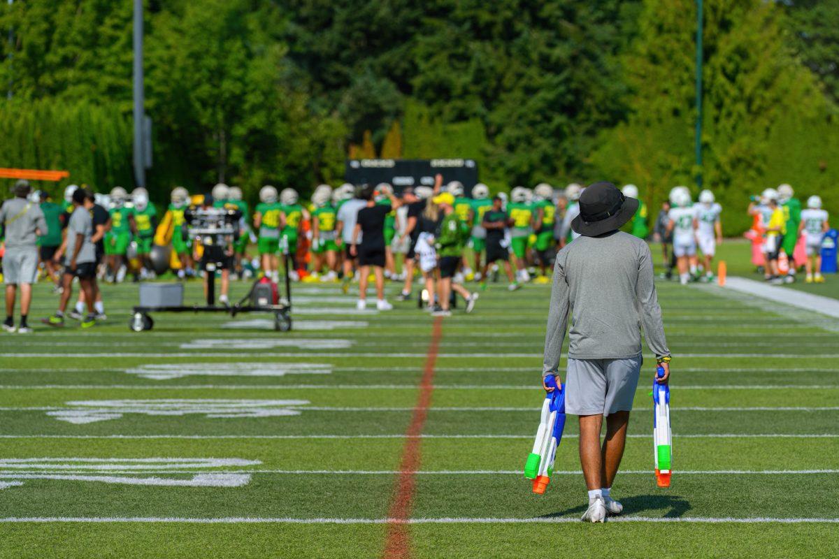 <p>A football staff member carries water guns onto the practice field. The University of Oregon Football team conducted their 17th fall practice on August 23, 2023, on the practice fields at Hatfield-Dowlin Complex, in Eugene, Oregon. (Eric Becker/Emerald)</p>