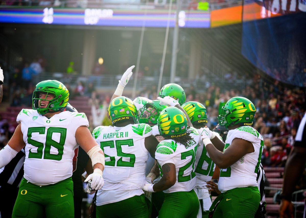 Terrance Ferguson (3) is crowded by teammates in the endzone after scoring a touchdown. The University of Oregon Ducks football team defeated the Stanford University Cardinals in an away match at Stanford Stadium in Stanford, Calif., on Sept. 30, 2023. (Eric Becker/Emerald)