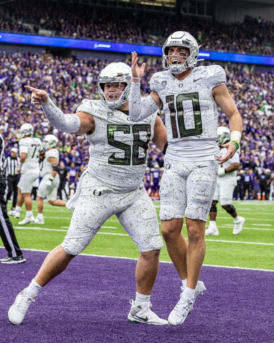 Bo Nix (10) celebrates with his center, Jackson Powers-Johnson (58), after clawing back from eleven point deficit and gaining the lead.&#160;The University of Oregon Ducks Football team were defeated by the University of Washington Huskies in an away match at Husky Stadium in Seattle, Washington, on October 14, 2023. (Jonathan Suni/Emerald)