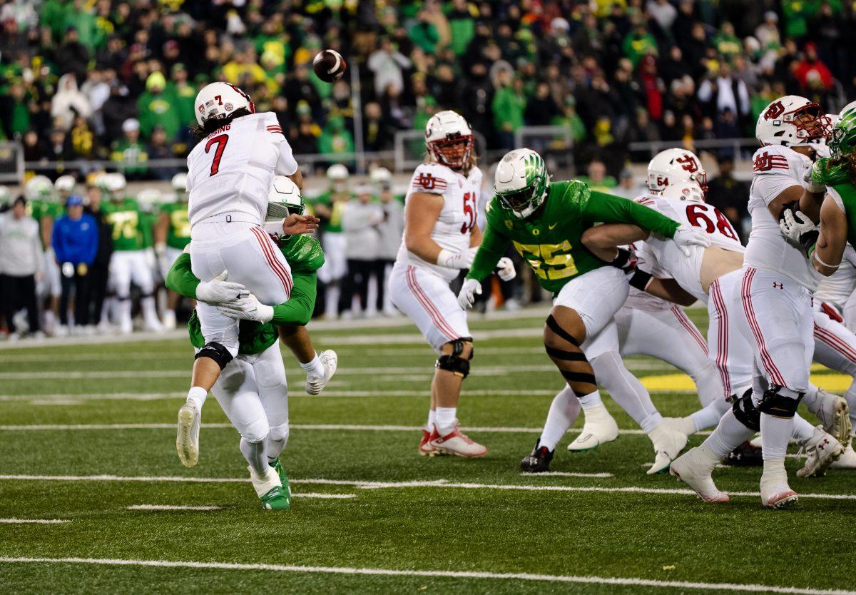 Brandon Dorlus hits Cameron Rising hard as he gets off the ball just in time. Oregon beats no.10 Utah on November 19th, 2022, at Autzen Stadium. (Liam Sherry, Emerald)