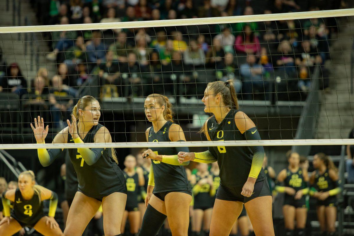 Ducks middle blocker, Colby Neal (7), outside hitter, Gabby Gonzalez (8), and setter, Hannah Pukis (9), all gather in front of the net as the Ducks prepare to set the ball. The University of Oregon Ducks volleyball team lost to Stanford 1-3 at Matthew Knight Arena in Eugene, Ore., on Oct. 22, 2023. (Sebastian Flores/Emerald)