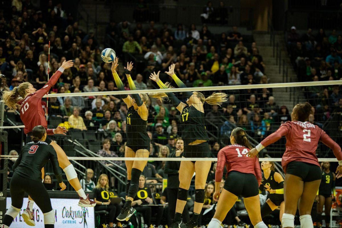 Ducks opposite Morgan Lewis (11) and middle blocker Kara McGhee (17) attempt a block against Stanford. The University of Oregon Ducks volleyball team lost to Stanford 1-3 at Matthew Knight Arena in Eugene, Ore., on Oct. 22, 2023. (Sebastian Flores/Emerald)