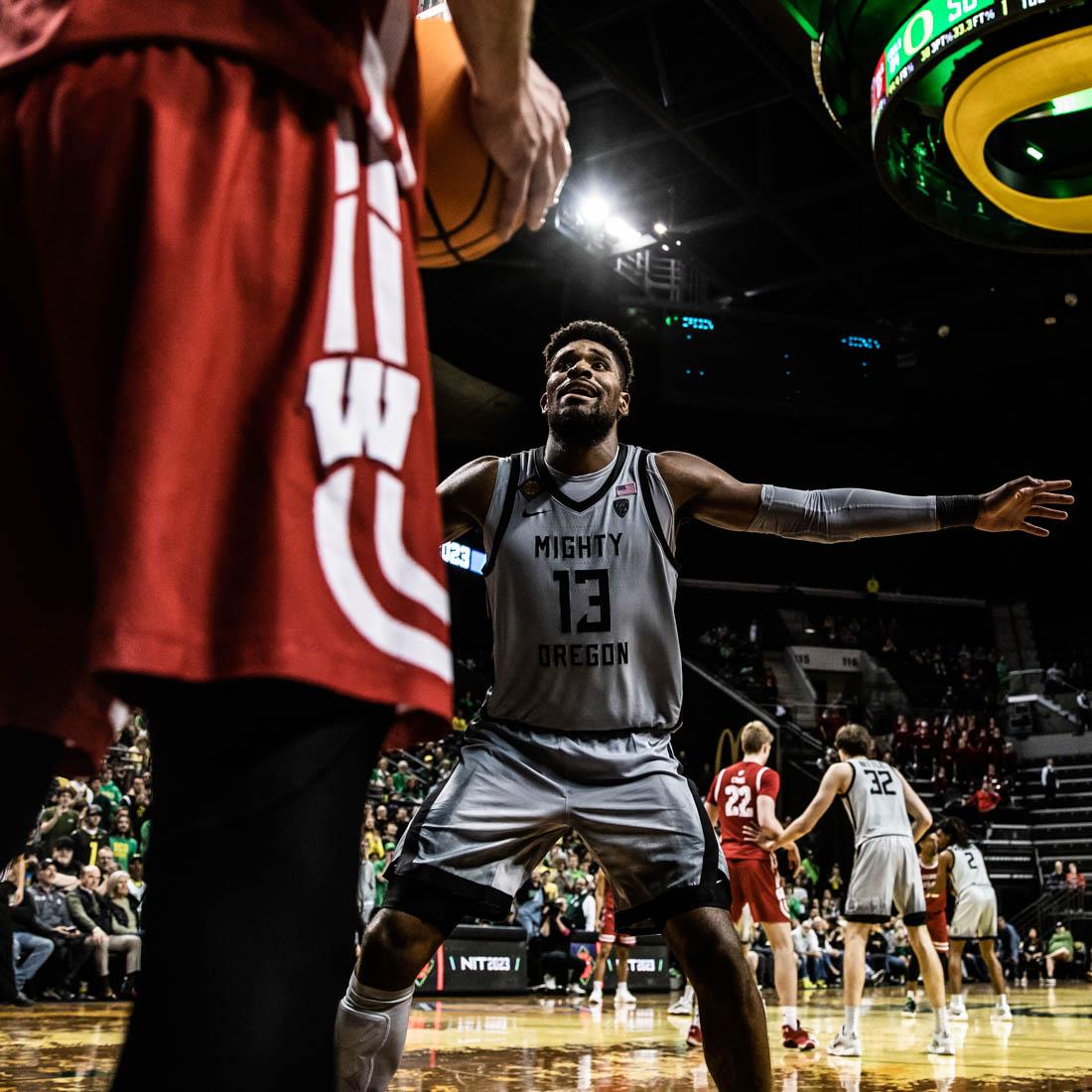 Ducks forward Quincy Guerrier (13) tries to block a throw-in by the Badgers. University of Oregon Mens Basketball take on the Wisconsin Badgers in round 3 of the National Invitational Tournament at Matthew Knight Arena in Eugene, Ore., on Mar. 21, 2023. (Maddie Stellingwerf/Emerald).