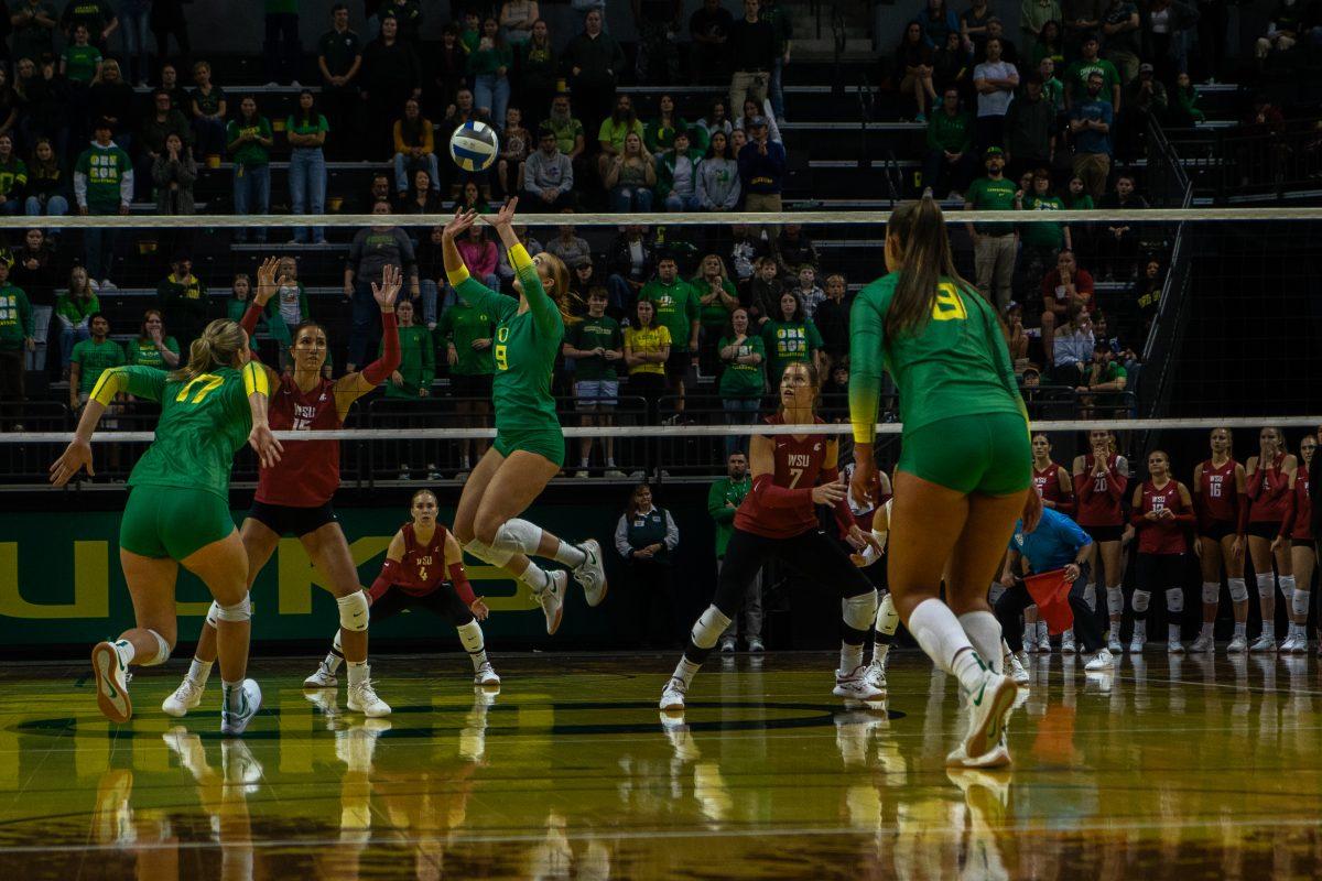 Hannah Pukis, setter (#9), sets the ball up for her teammate, Kara McGhee, middle vlocker (#17). (Lulu Devoulin/Daily Emerald)