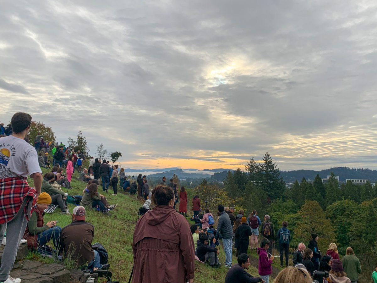 Many gather early in the morning at Skinners Butte to watch the solar eclipse on October 14, 2023 (Kai Kanzer/Emerald)