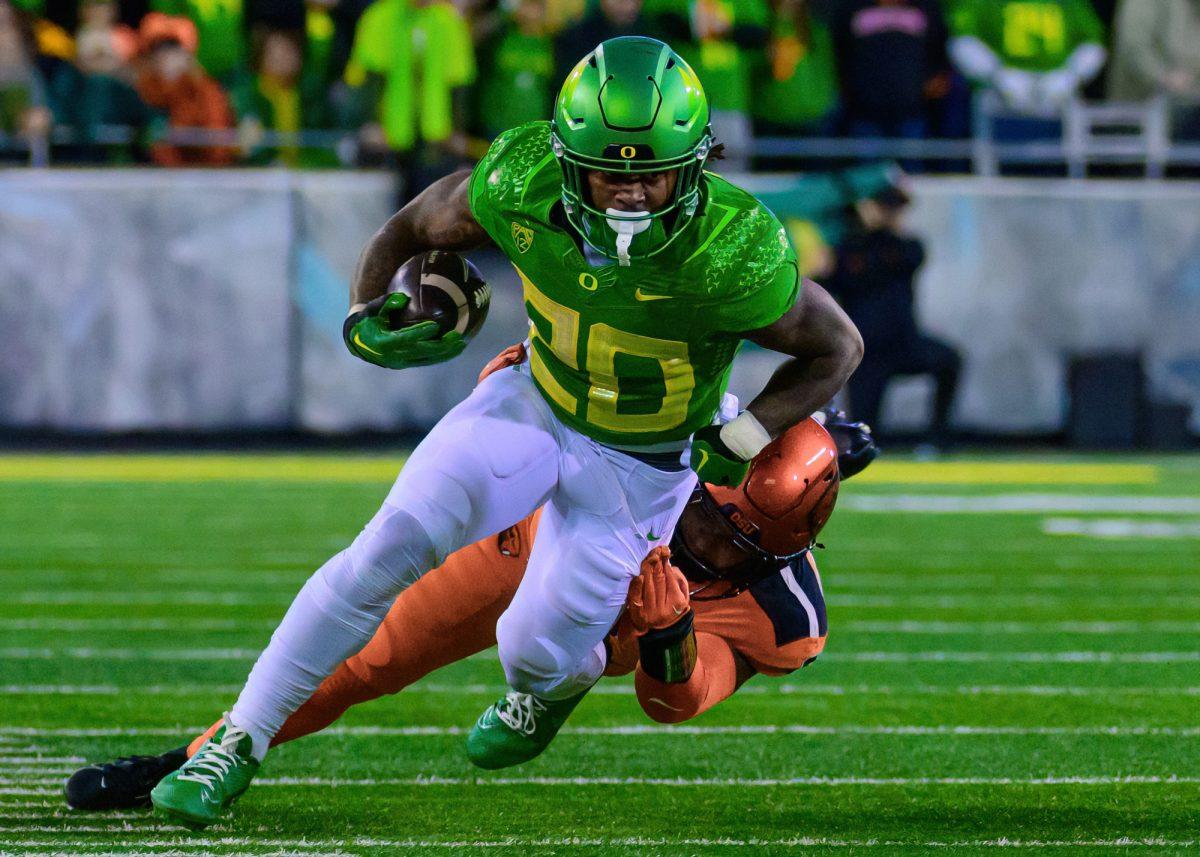 <p>Oregon RB Jordan James (20) shakes off a OSU defender. The University of Oregon Ducks Football team defeated Oregon State University 31-7 in a home match at Autzen Stadium in Eugene, Ore., on Nov. 24, 2023. (Eric Becker/Emerald)</p>