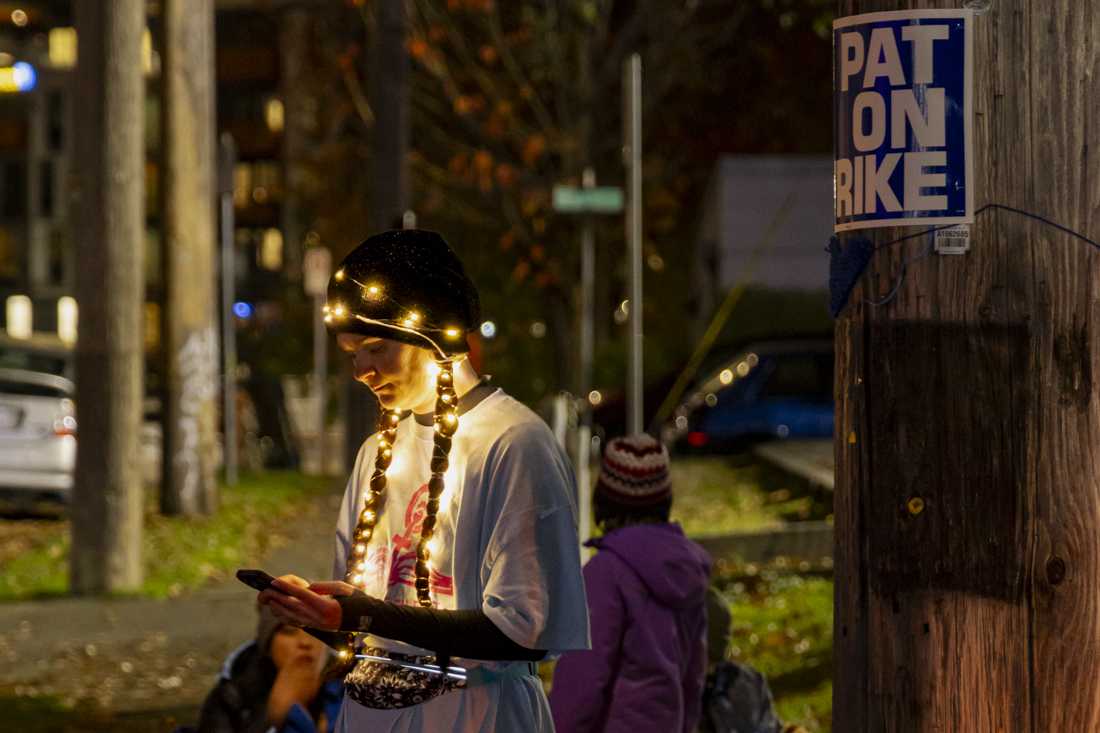 After the dance party, a woman stands near a "PAT ON STRIKE" sign posted outside of the PPS district office. (Alex Hernandez/Emerald)