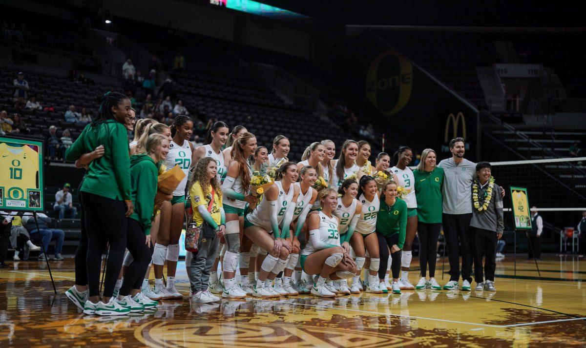 Coaches and playes pose for a group photo. Oregon Volleyball take on University of Southern California at Matthew Knight Arena in Eugene, Ore. on Nov. 21st, 2023. (Eddie Bruning/Emerald)