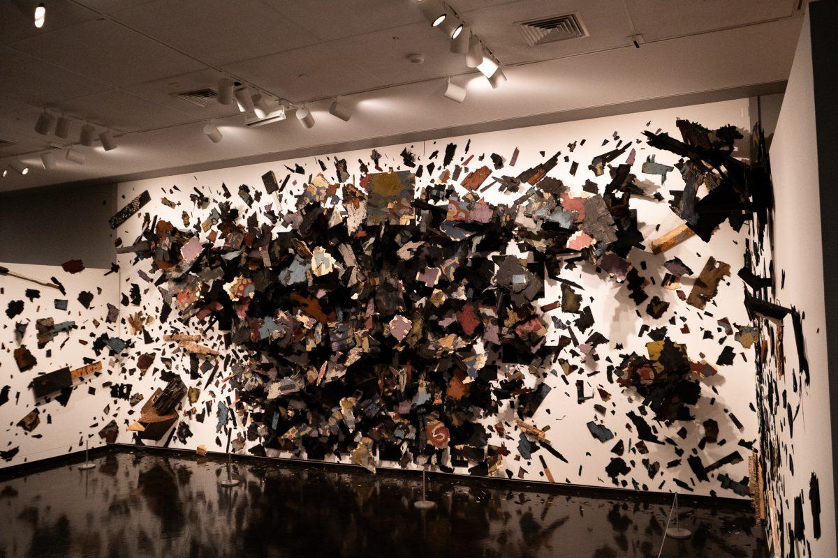 A wide angle shot of Leonardo Drew&#8217;s art piece, &#8220;Number 215B,&#8221;that depicts a large room full of wood splinters across the wall jutting out to the edges recalling the wreckages that are brought upon us during &#8220;natural&#8221; disasters. 'Strange Weather' at the Jordan Schnitzer Museum of Art is on display from Oct 21st to Apr. 7th, 2024. (Sebastian Flores/Emerald)