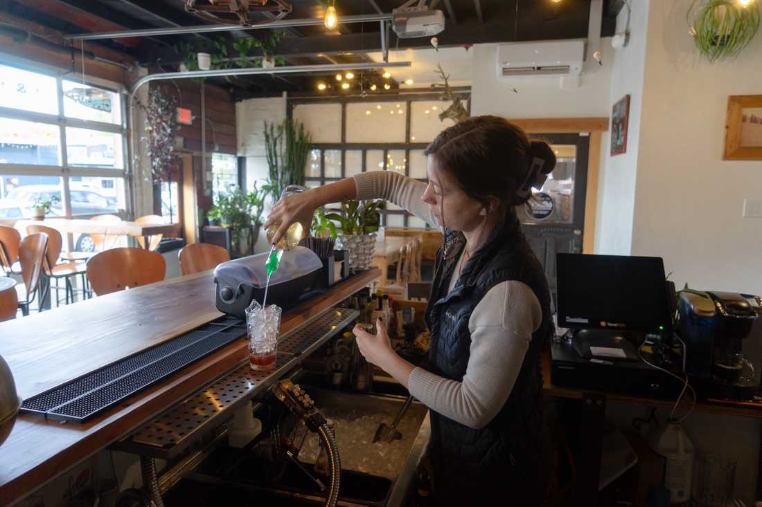 An employee mixes a new drink on the bar's menu, the "sugar plum vice". Crow and Cart is a cozy bar located in Eugene's Whitaker neighborhood. (Lulu Devoulin/ Emerald)