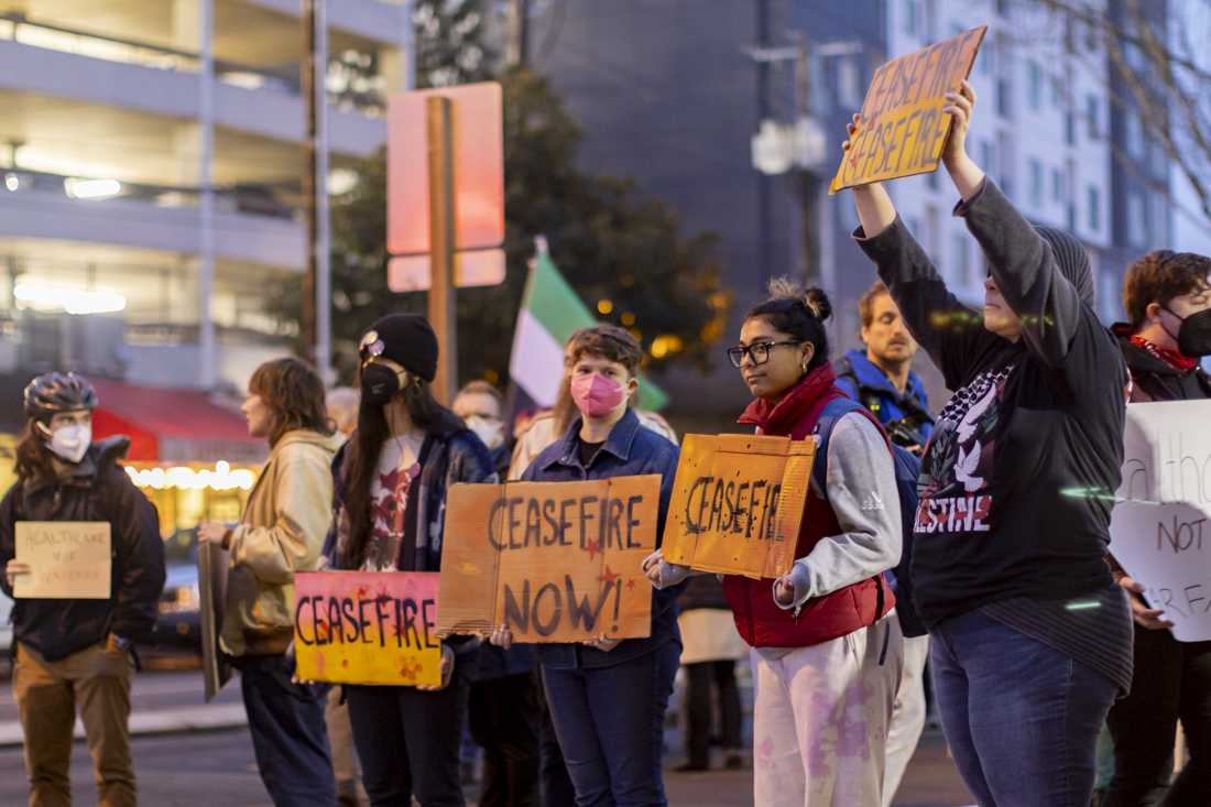 <p>People participate in a demonstration calling for a ceasefire in Gaza. The demonstration took place on Nov. 15 on the corner of 13th and Hilyard streets, just outside of the PeaceHealth University District Hospital. (Alex Hernandez/Emerald)</p>