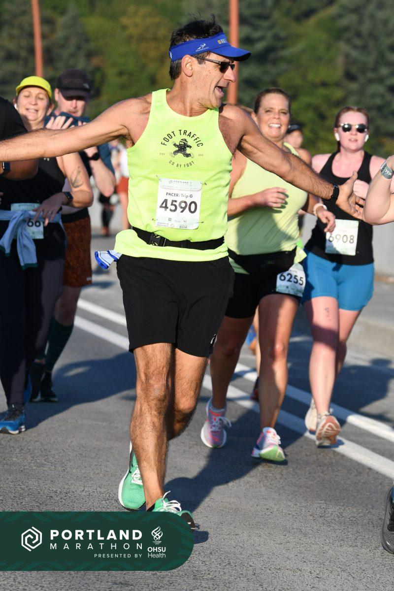 <p>Gregg LeBlanc cheers on the runners around him as he paces the Portland marathon.</p>