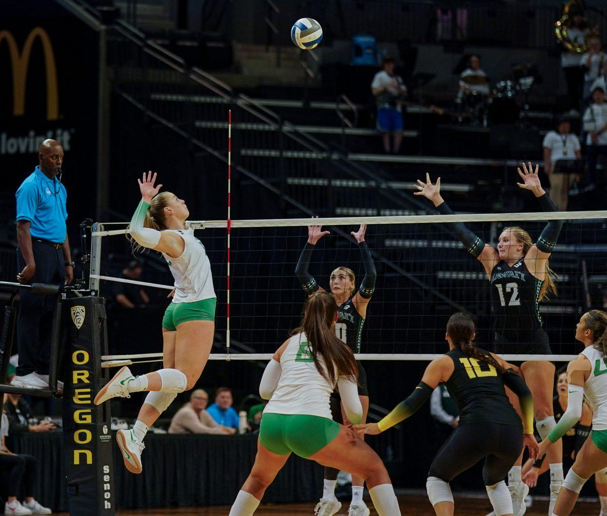 Mimi Colyer (15) delivered a powerful strike through the teeth of Hawaii's defense. Oregon Volleyball take on the University of Hawaii at Matthew Knight Arena in Eugene, Ore. on Dec 1, 2023. (Eddie Bruning/Emerald)