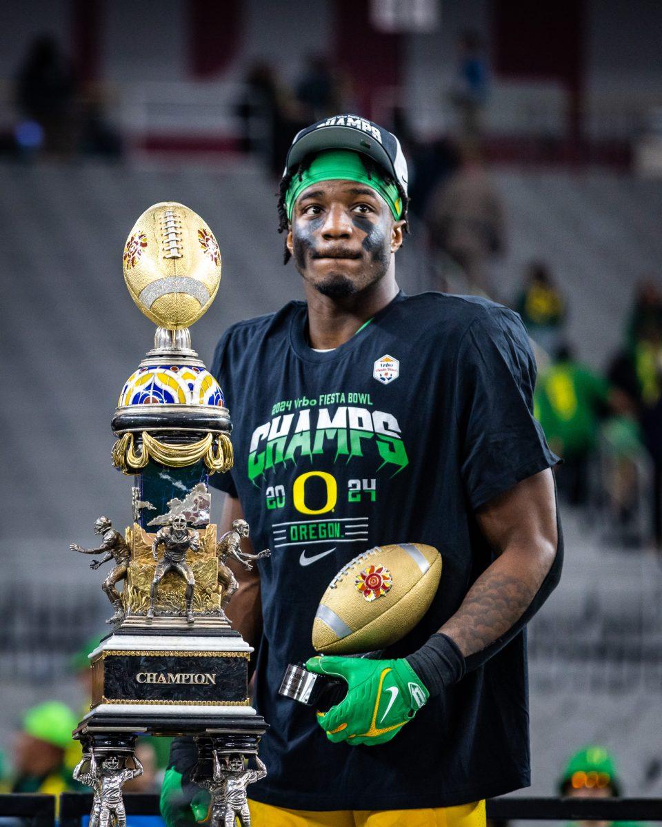 Jeffery Bassa holds his defensive MVP trophy and soaks in the moment on stage ahead of his decision on returning for his senior season or declaring for the NFL draft.&#160;The Oregon Ducks crush the Liberty Flames at State Farm Stadium in Glendale, Ariz., on Jan. 1, 2024. (Jonathan Suni/Emerald)