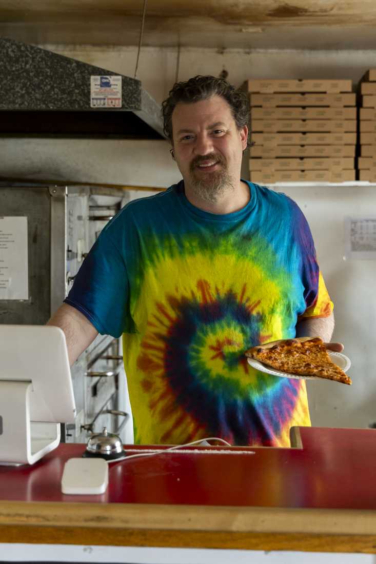 Josh Zweifler poses for a portrait inside of Sy's Pizza on Feb. 7, 2024. Zweifler is the newest owner of the shop, which dates back to 1978. (Alex Hernandez/Emerald)