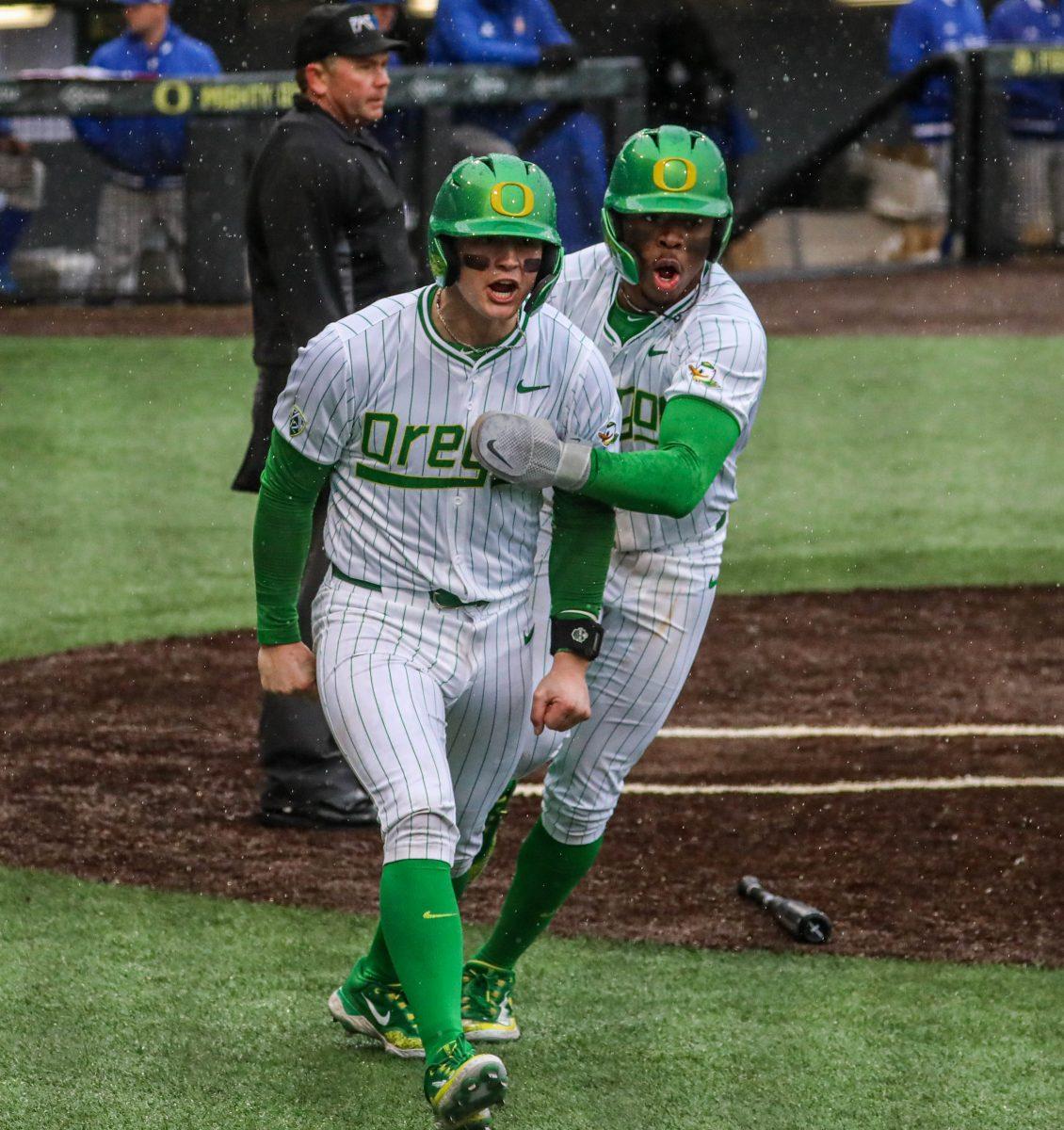 Drew Smith (Left) and Jeffery Heard (right) each score to help the Ducks avoid a 3 game sweep. The Oregon Ducks Baseball team defeat UC Santa Barbara 16-9 in Game 3 of the series at PK Park in Eugene, Ore., on March 3, 2024. (Kai Kanzer/Emerald)