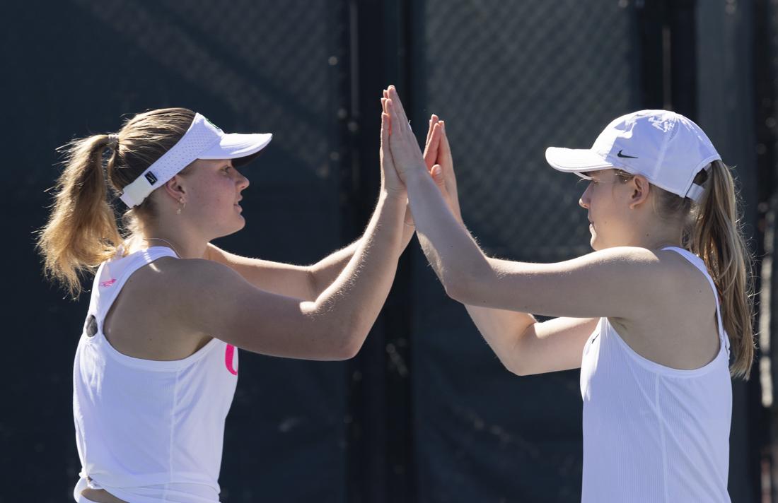 Tilde Jagare (left) and Sophie Luescher (right) high five. The Oregon women's tennis team walked away victorious after facing off against the University of Portland team at the UO student tennis center on March 16, 2024. (Alex Hernandez/Emerald)