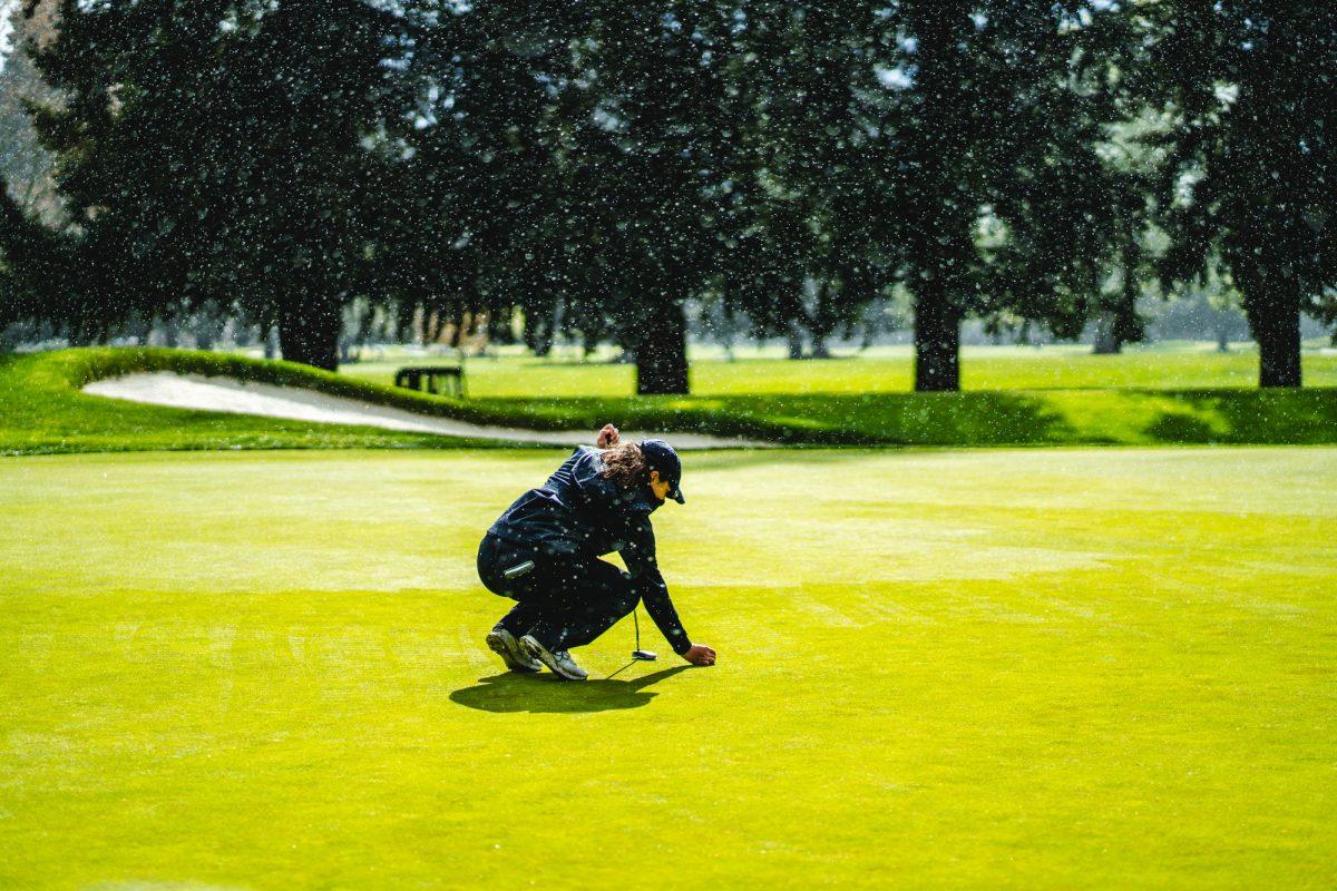 Madelyn Gamble, a golfer for Washington State University, prepares to putt as rain begins to fall. The Eugene Country Club hosted the Pac-12 women's golf championships from April 18-20, 2022. (Will Geschke/Emerald)