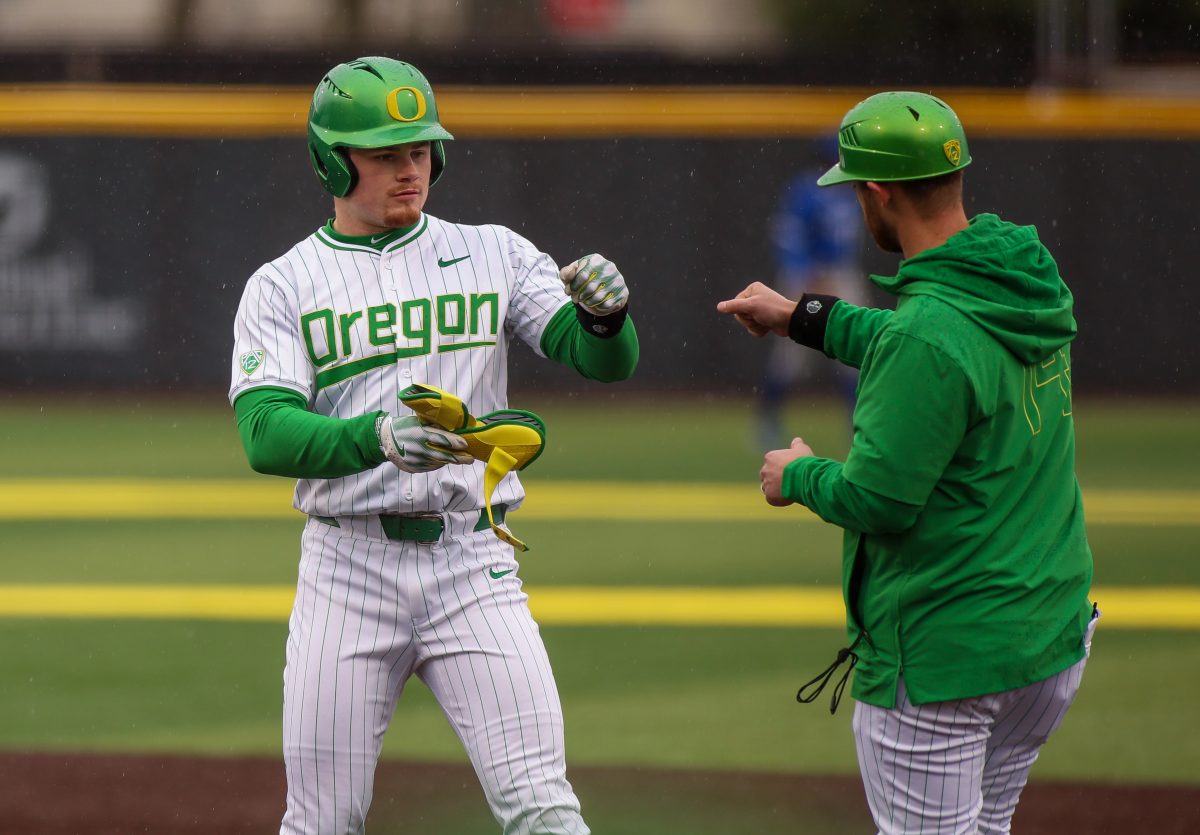 Oregon's Bryce Boettcher (28) fist bump the first base coach after hitting a double in the bottom of the 2nd. Oregon Baseball take on UC Santa Barbara at PK Park in Eugene, on March 3 , 2024. (Eddie Bruning/Emerald)