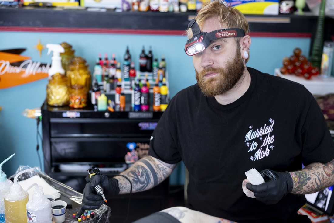 Mark Mullins looks up from tattooing a client at The Parlour Tattoo on March 24, 2024. (Alex Hernandez/Emerald)