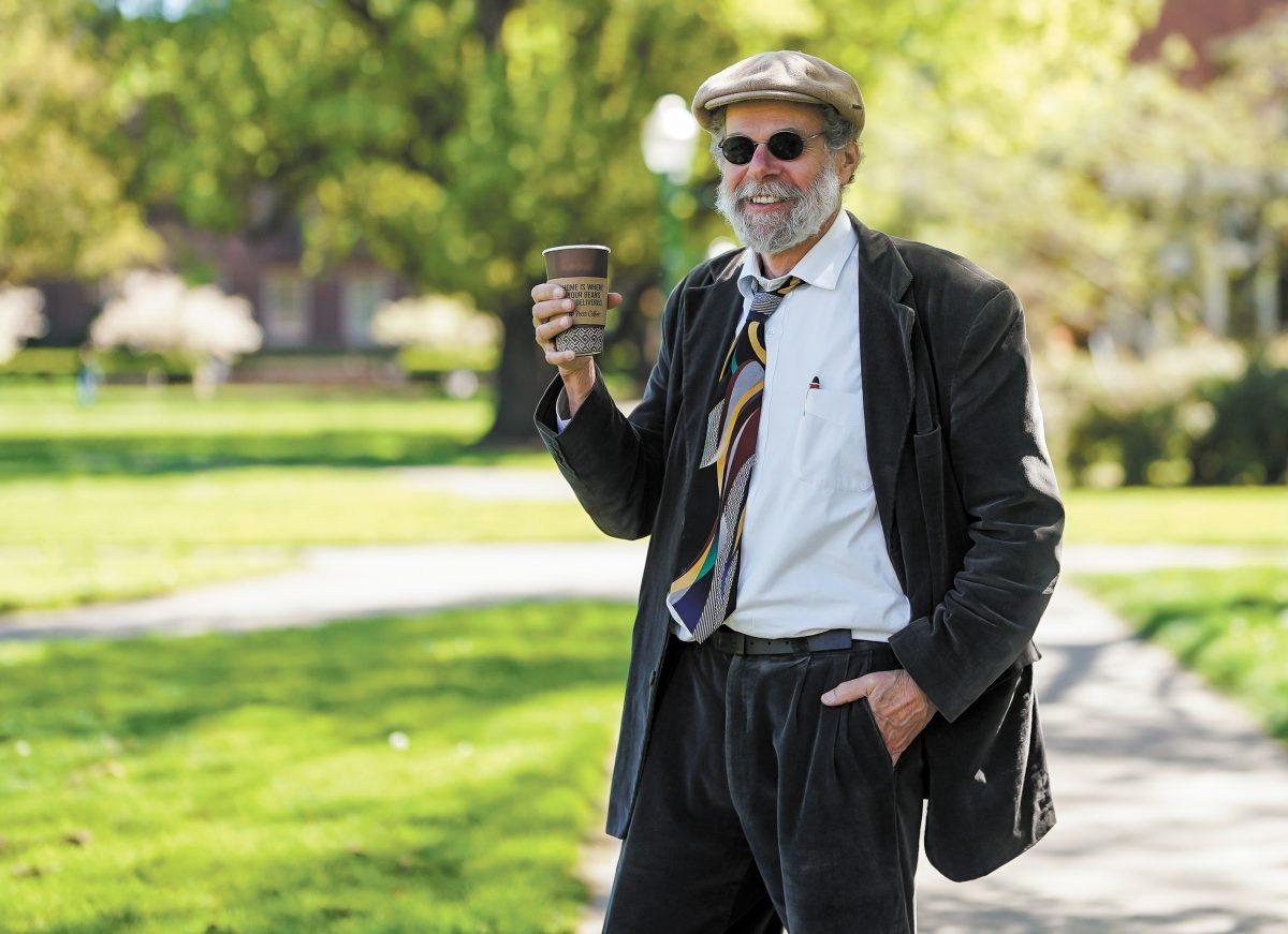 Professor Laufer holding one of his tools for being a Professor outside of Knight Library. Professor-Core Fashion, Eugene, on April 17, 2024. (Eddie Bruning/Emerald)