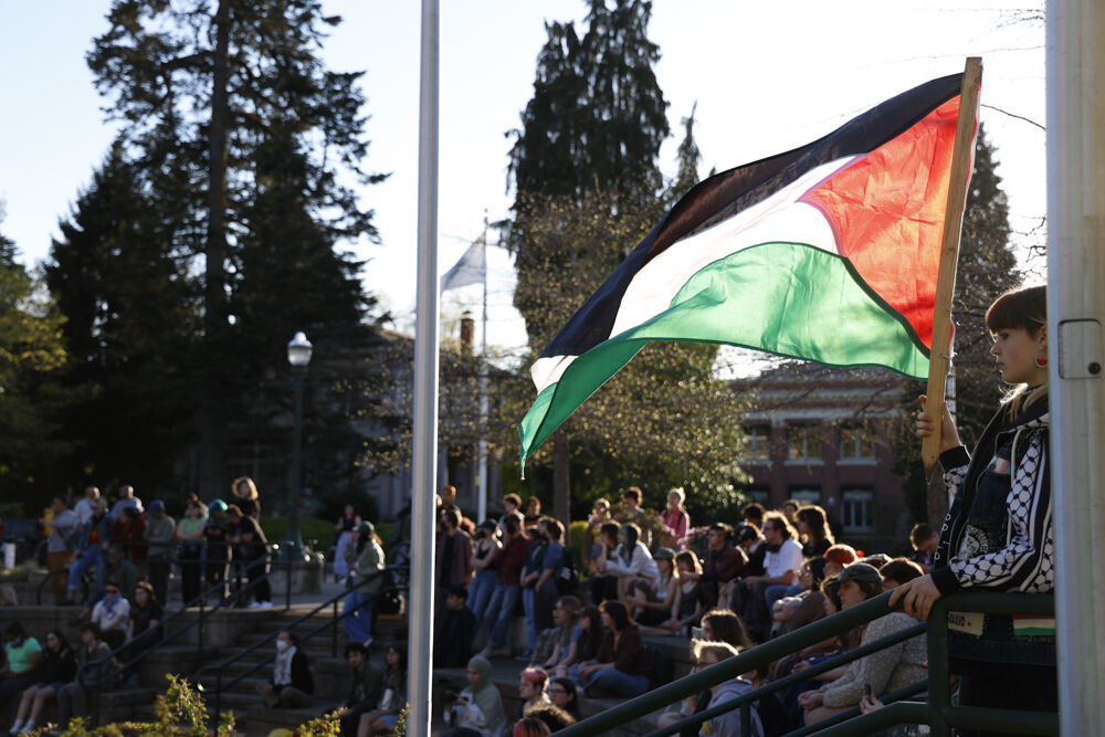 A protester holds a Palestinian flag outside of the EMU on April 18, 2024. The UO Students for Justice in Palestine and Jewish Voice for Peace demonstration was held in protest of an event organized by the student group Ducks 4 Israel&#8212;"60 Days of Uncertainty," a presentation and Q&amp;A by former IDF soldier, Adiel Cohen. (Alex Hernandez/Emerald)