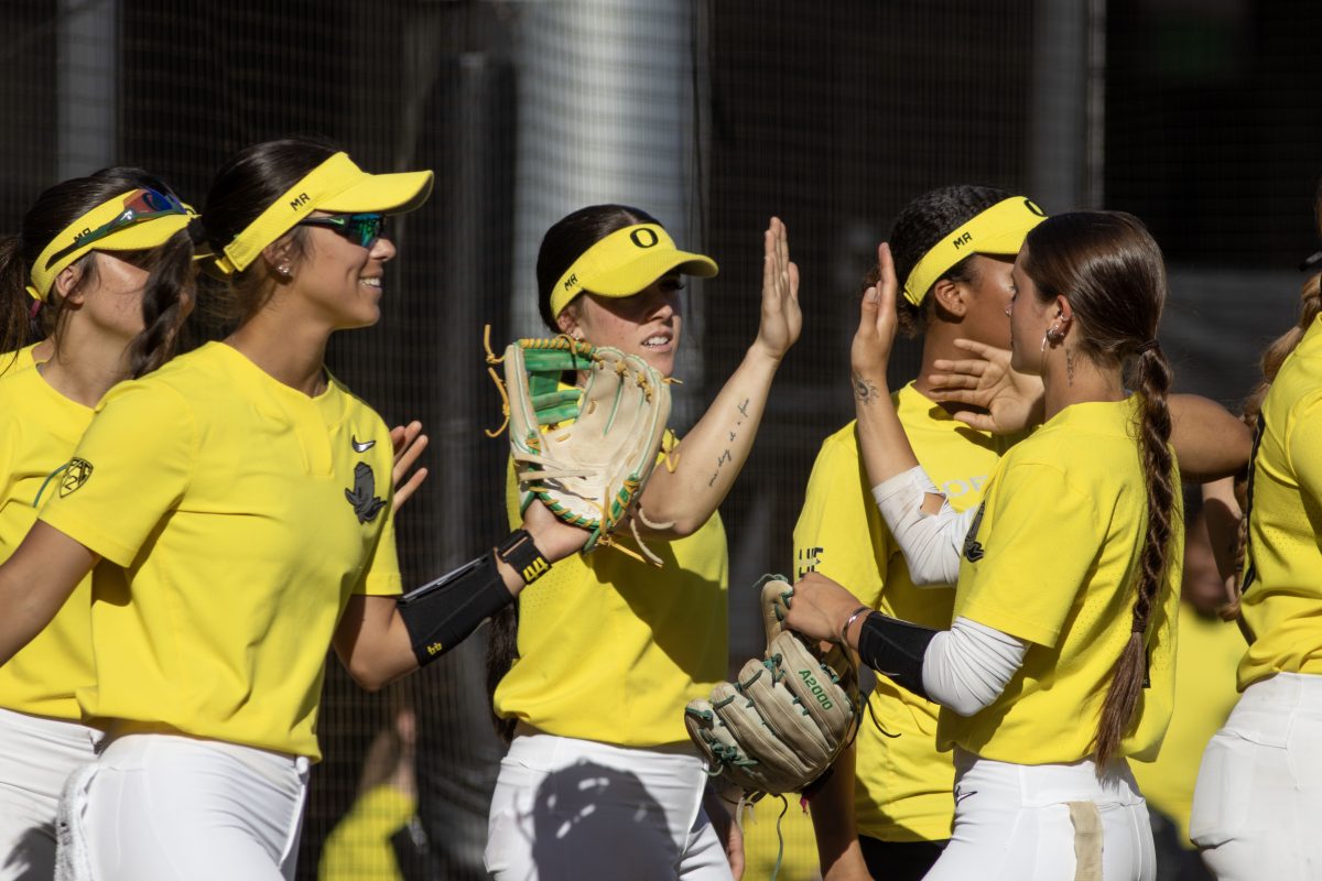 KK Humphreys (13) and Kedre Luschar (1) celebrate the end of the first inning by sharing a high five.The Oregon Softball team secures the win 11-3 over Oregon State in game 1 of their Rivalry Series, hosted at Jane Sanders Stadium in Eugene, Ore., on April 19, 2024. (Alyssa Garcia/Emerald)