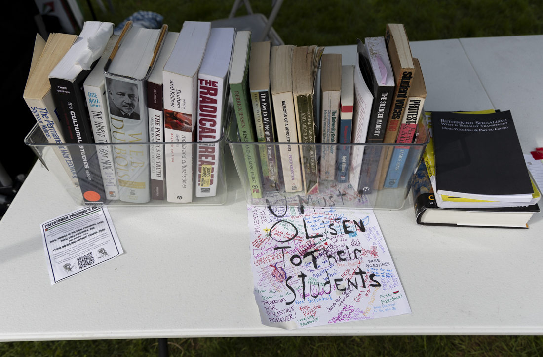 Pro-Palestine messages, alongside a paper reading "UO Must Listen To Their Students," sit next to literature about politics, protests and revolutions inside of the encampment on May 1, 2024. This is the third day of the encampment demonstration, which has seen more demonstrators join each day; the protest is one of many across college campuses nationwide. (Alex Hernandez/Emerald)