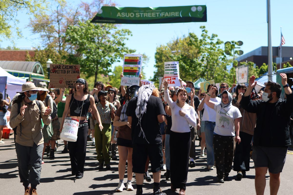 After marching around the EMU, protesters walk through the ASUO Street Faire. On May 10, 2024, hundreds of protesters marched through campus after UO officials did not appear for negotiations. (Colleen Bogdan/Emerald)