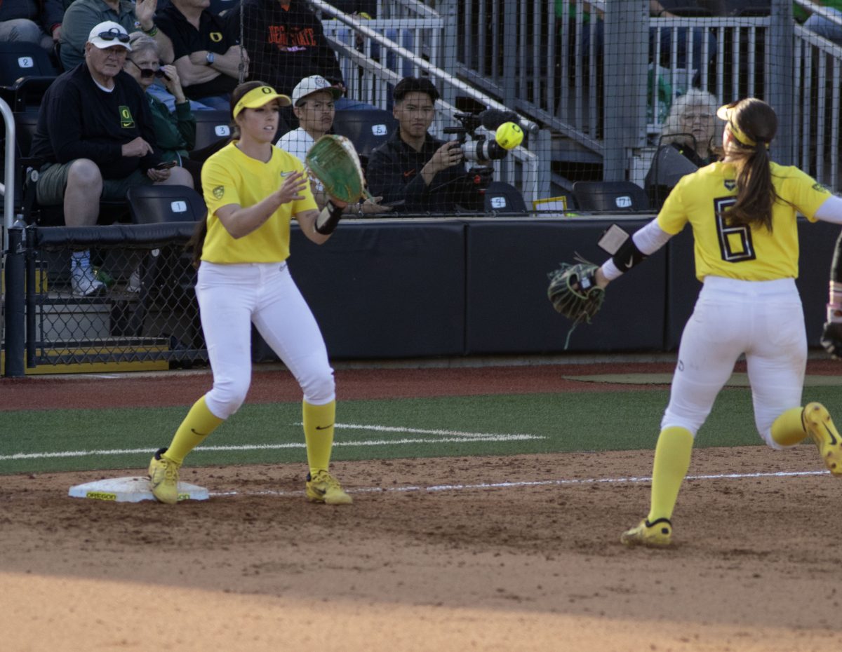 Katie Flannery (6) passes the ball to KK Humphreys (13) to get the Oregon State runner out. The Oregon Softball team secures the win 11-3 over Oregon State in game 1 of their Rivalry Series, hosted at Jane Sanders Stadium in Eugene, Ore., on April 19, 2024. (Alyssa Garcia/Emerald)