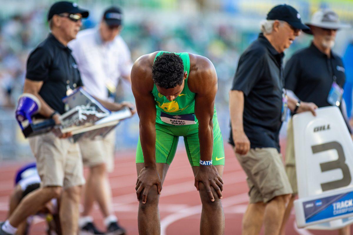 Volunteer workers scramble to get the next event ready as Rafael Raap takes a moment to himself after a bit of a disappointing performance in the 400m portion of the decathlon. Raap looks to improve on his scores on day two with plenty of field events to compete in the decathlon for.&#160;The top athletes in college track and field meet in the iconic Hayward Field for the NCAA Championships in Eugene, OR, from June 5th to June 8th, 2024. (Jonathan Suni, Emerald)