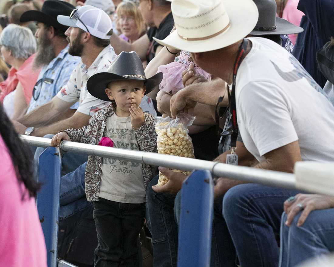 People eat snacks and watch the rodeo events on July 3, 2024. The Eugene Pro Rodeo kicked off its first day with the theme of "Tough Enough to Wear Pink," in support of cancer awareness. (Alex Hernandez/Emerald)