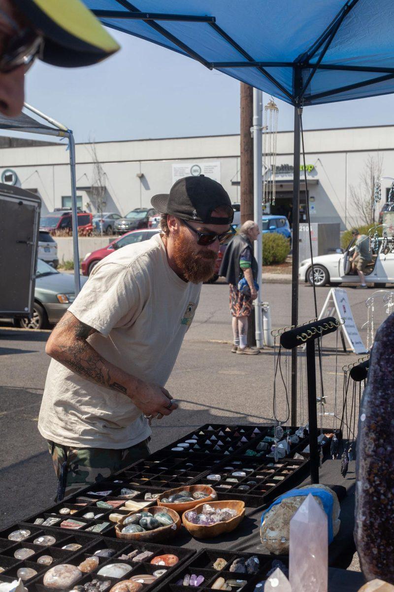 Vendor Jeff McMann checks out the products of another stall. (Miles Cull/Emerald)