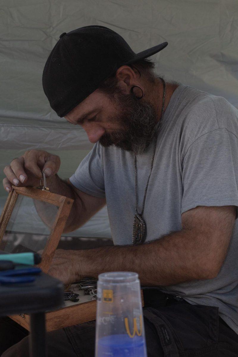 Jewelry maker, Brian Dickinson, puts a newly finished necklace into a viewing case. (Miles Cull/Emerald) 