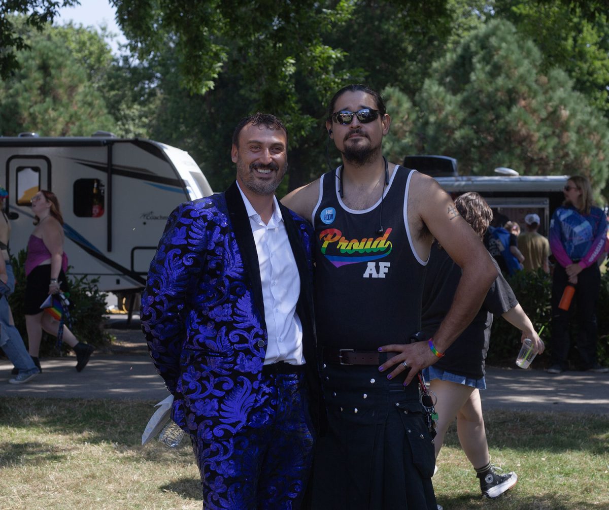 A performer at Eugene Pride in the Park, Emperor of Eugene, Johnny Doone Foxx, and Rob V pose for a picture. (Miles Cull/Emerald)