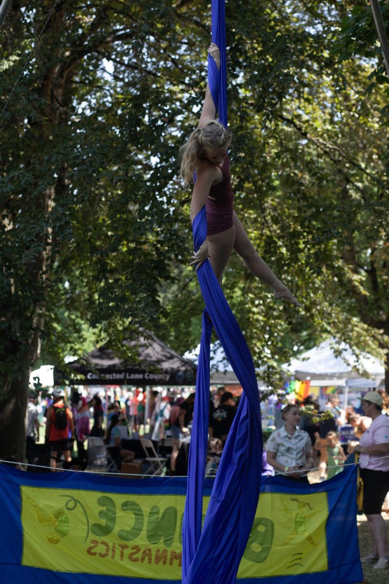 Preformers from Bounce Gymnastics twirl under the shade at Eugene Pride in the Park. (Miles Cull/Emerald)