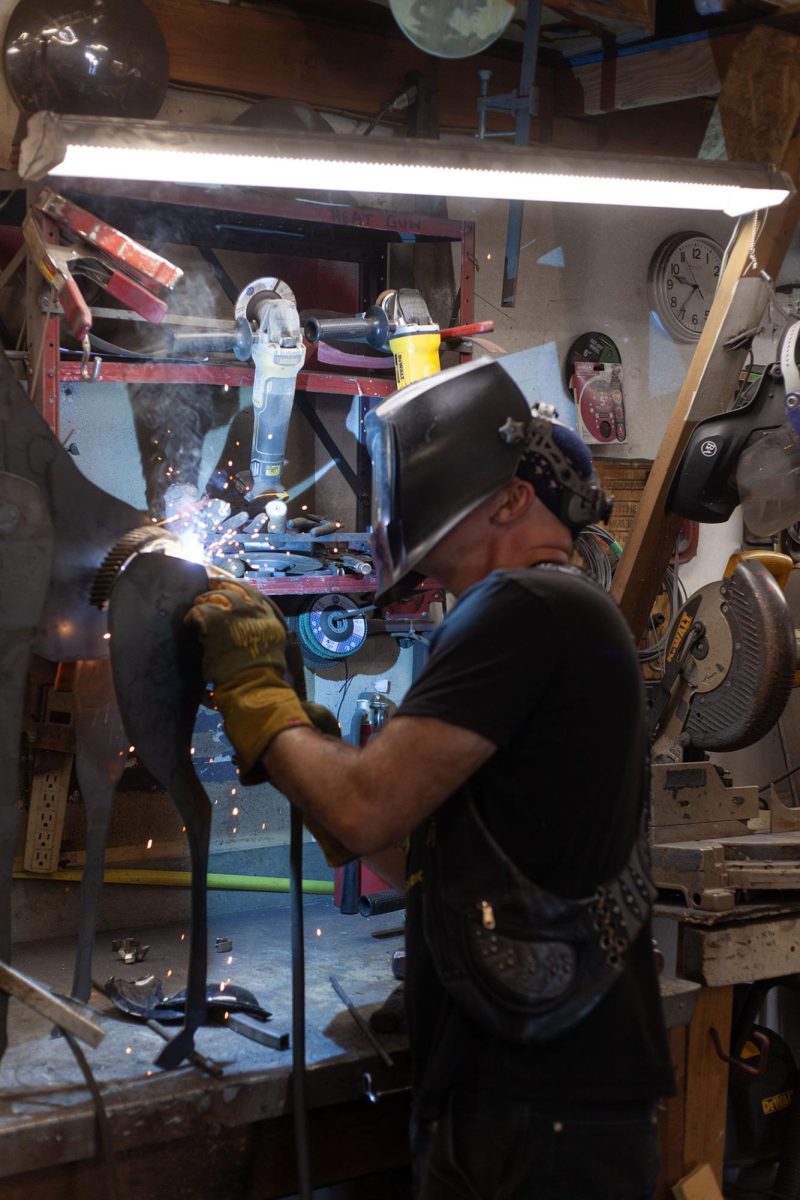 Jud Turner works on a new sculpture at his studio next to The Oblivion Gallery, unveiled August 3. Turner said that the studio provided him and his wife, Renee Mahni, a place for people to experience their sculptures. They plan to host a guest artist in the gallery the first Saturday of each month. (Miles Cull/Emerald)